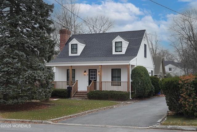 cape cod-style house featuring a porch and a front yard