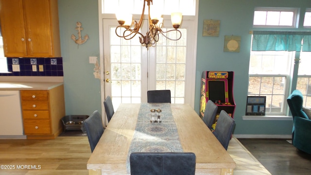 dining room featuring a wealth of natural light, light hardwood / wood-style flooring, and a notable chandelier