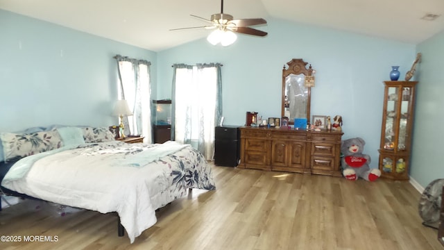 bedroom with ceiling fan, lofted ceiling, and light hardwood / wood-style flooring