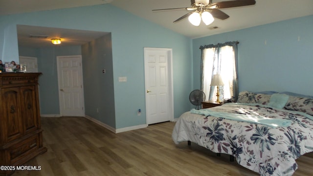 bedroom with ceiling fan, lofted ceiling, and wood-type flooring