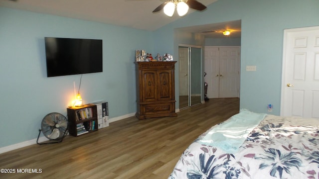 bedroom featuring vaulted ceiling, a closet, hardwood / wood-style flooring, and ceiling fan