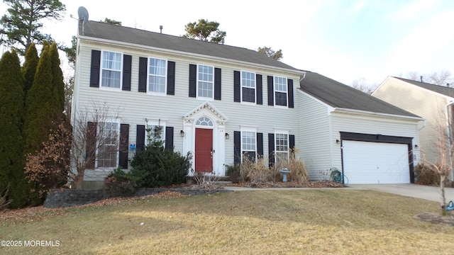 colonial inspired home with a front lawn and a garage