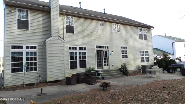 rear view of house featuring cooling unit, a fire pit, and a patio