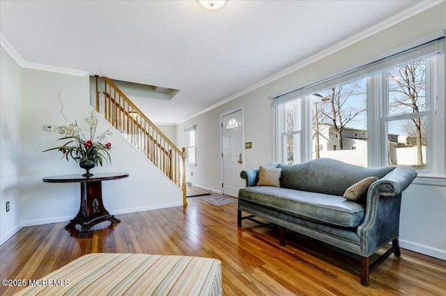 living room with ornamental molding, wood finished floors, baseboards, and stairs