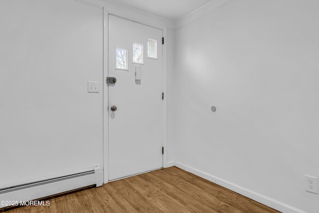 foyer entrance featuring crown molding, light hardwood / wood-style flooring, and a baseboard radiator