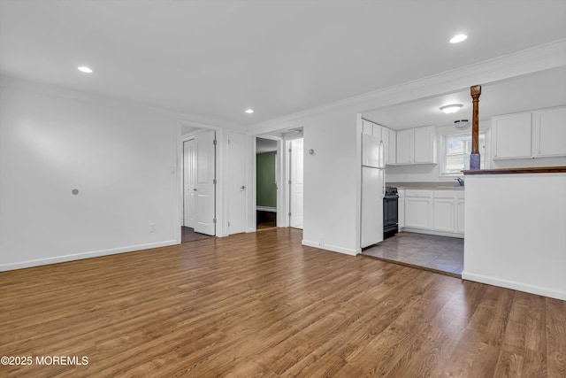 unfurnished living room with ornamental molding, light hardwood / wood-style floors, and sink