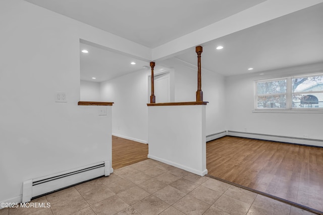 empty room with baseboard heating and light hardwood / wood-style floors