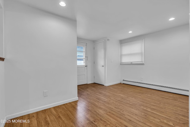 spare room with light hardwood / wood-style floors and a baseboard radiator