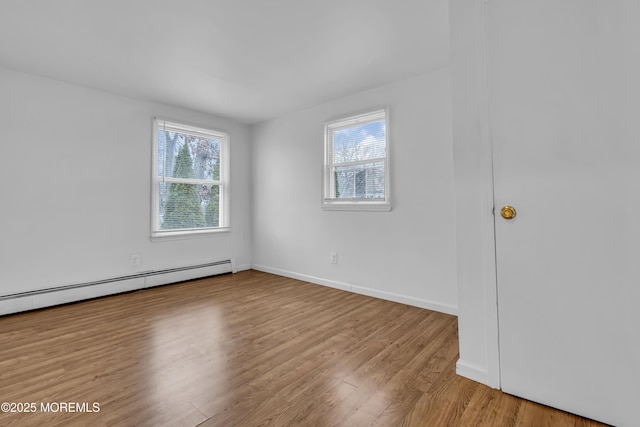 unfurnished room with light wood-type flooring and baseboard heating