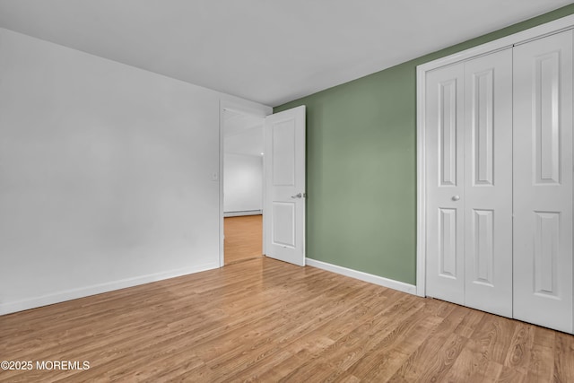 unfurnished bedroom featuring light hardwood / wood-style floors and a closet