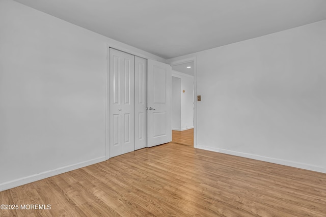 unfurnished bedroom featuring light hardwood / wood-style floors and a closet