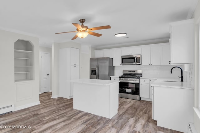 kitchen with a center island, sink, white cabinetry, appliances with stainless steel finishes, and built in shelves