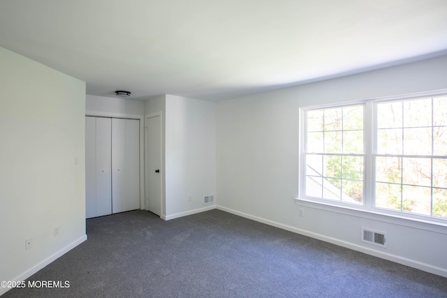 unfurnished bedroom with dark carpet