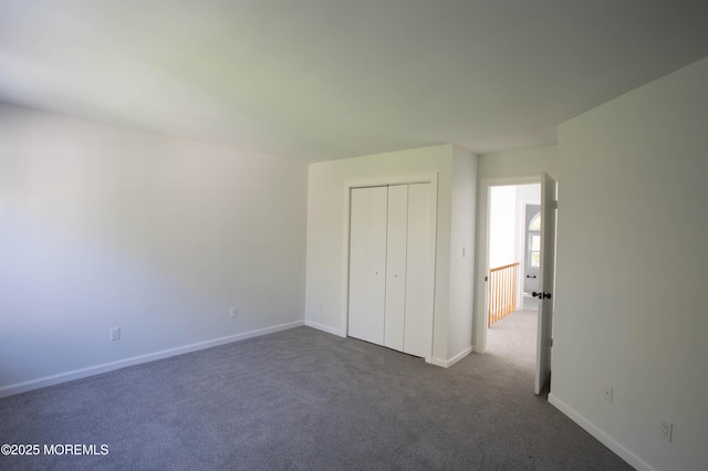 unfurnished bedroom featuring dark carpet and a closet