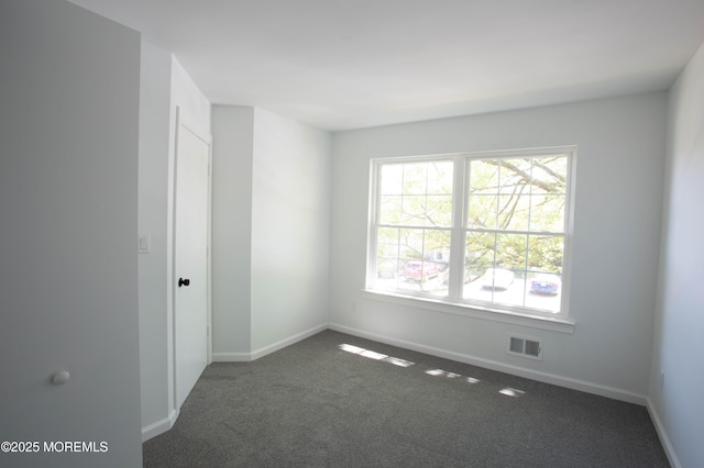 spare room with dark colored carpet