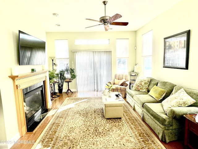 living room with ceiling fan, wood-type flooring, and a wealth of natural light