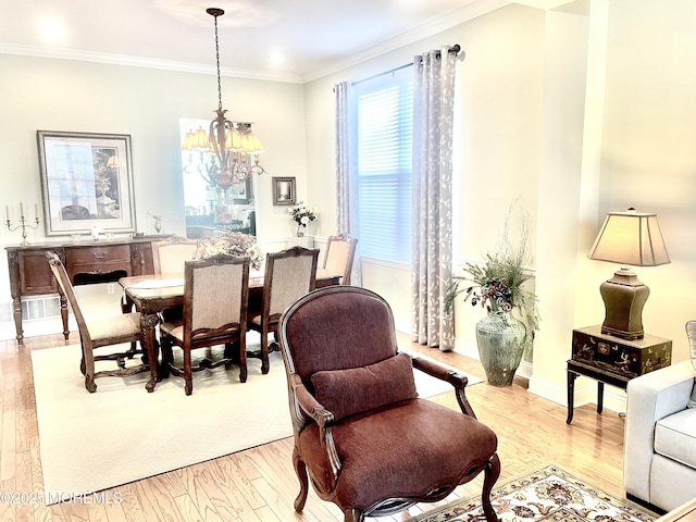 dining area featuring light hardwood / wood-style flooring, crown molding, and an inviting chandelier