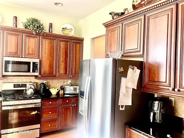 kitchen with backsplash and appliances with stainless steel finishes