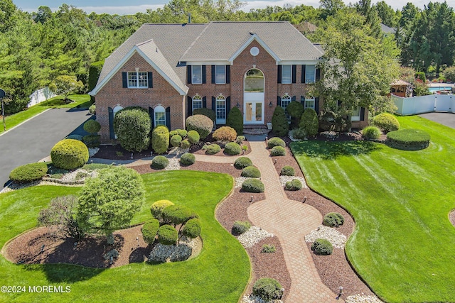 colonial-style house featuring a front lawn