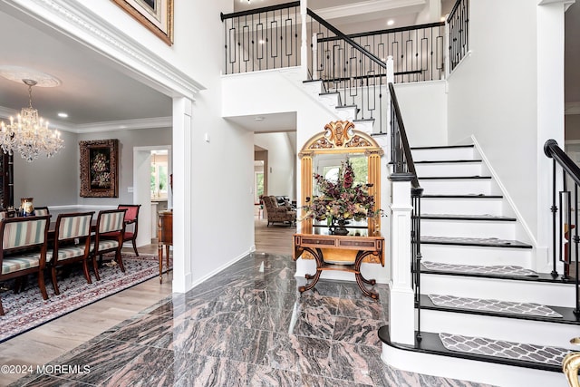 entrance foyer with an inviting chandelier and ornamental molding