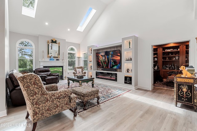 living room with high vaulted ceiling, built in features, and light hardwood / wood-style flooring