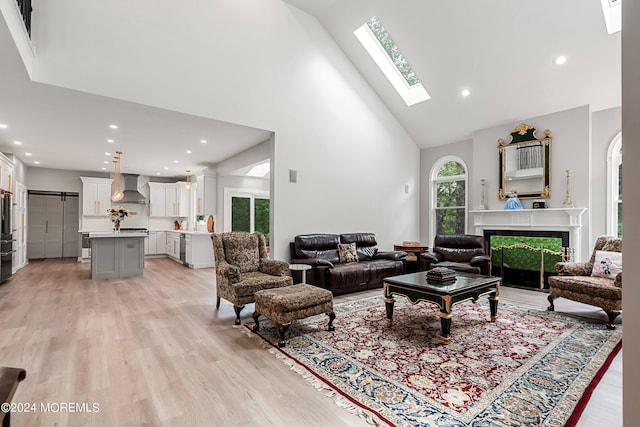 living room with high vaulted ceiling and light hardwood / wood-style flooring