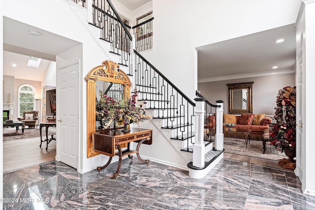 stairway with a skylight and crown molding