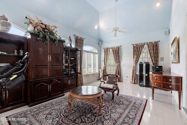 sitting room with high vaulted ceiling, light tile patterned floors, and ceiling fan