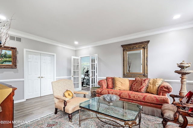 living room featuring wood-type flooring, ornamental molding, and french doors