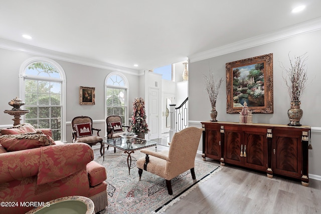 living room with light wood-type flooring and crown molding