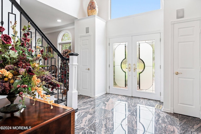 entryway featuring a healthy amount of sunlight, french doors, a high ceiling, and ornamental molding