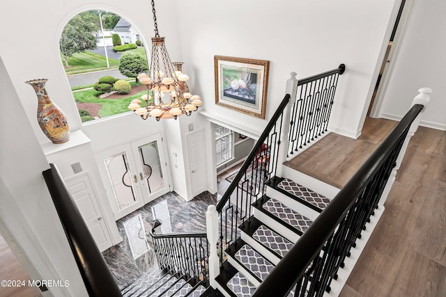 stairway featuring a high ceiling and a chandelier