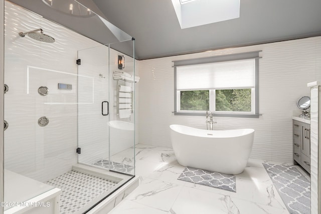 bathroom with vanity, a skylight, tile walls, and shower with separate bathtub