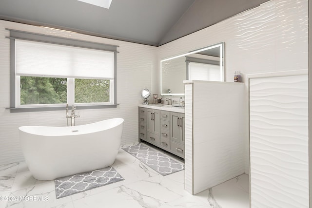 bathroom with vaulted ceiling, a tub to relax in, and vanity