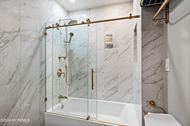 bathroom featuring toilet and combined bath / shower with glass door