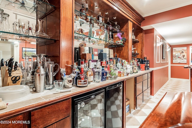 bar with tile countertops, crown molding, and beverage cooler