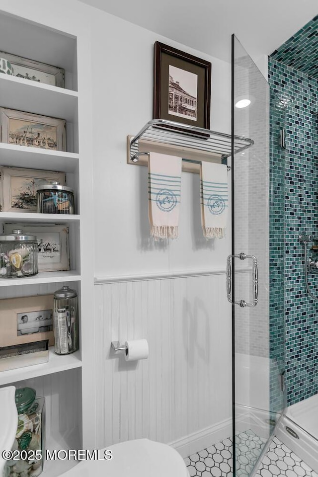 bathroom with toilet, walk in shower, and tile patterned flooring