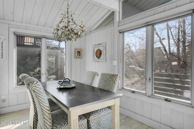 dining room with vaulted ceiling, light hardwood / wood-style flooring, an inviting chandelier, and a healthy amount of sunlight