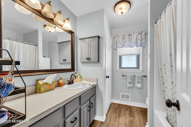 full bathroom with toilet, shower / bath combination with curtain, hardwood / wood-style flooring, and vanity