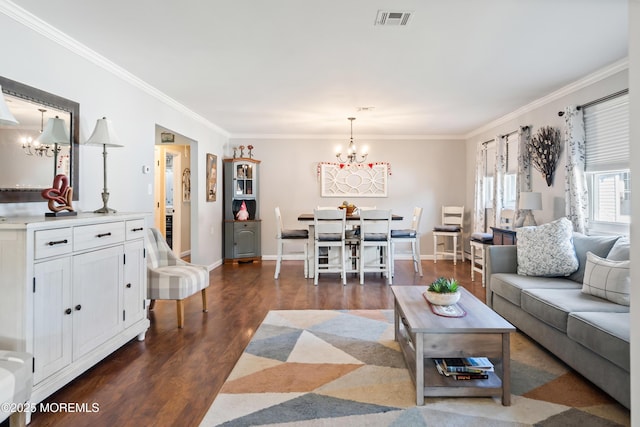 living room with dark wood-type flooring, ornamental molding, and an inviting chandelier