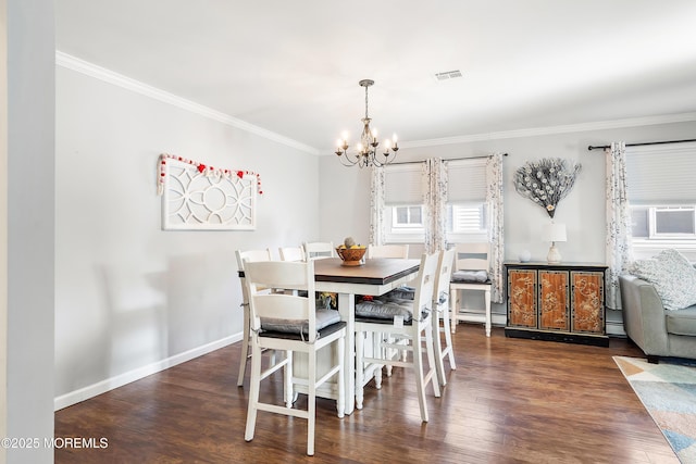 dining room with dark wood-type flooring, ornamental molding, and a notable chandelier