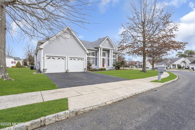 view of front of house featuring a front lawn, a garage, and cooling unit