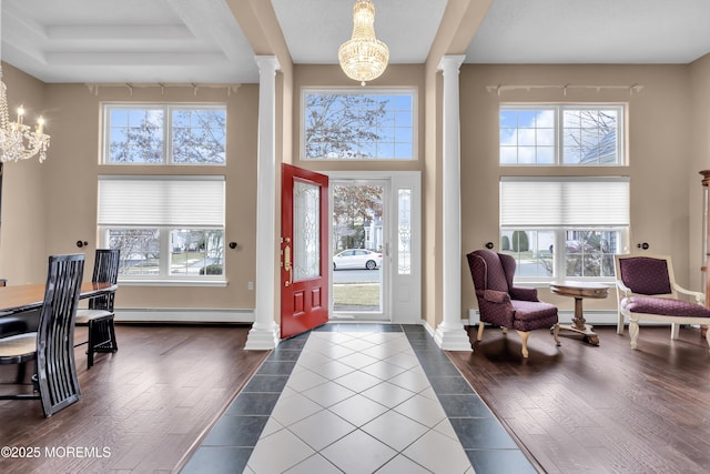 entrance foyer featuring a chandelier, wood-type flooring, and decorative columns