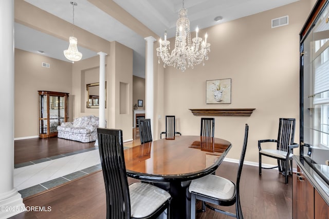 dining area with ornate columns, a chandelier, and dark tile patterned floors