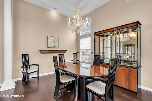 dining room featuring dark hardwood / wood-style flooring, a chandelier, and decorative columns