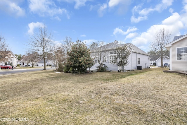 view of property exterior with central AC unit and a lawn