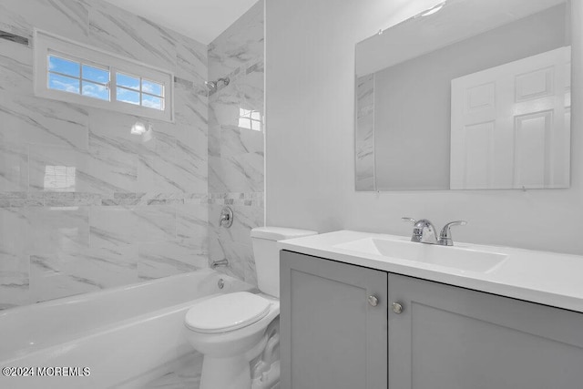 full bathroom featuring toilet, tiled shower / bath, and vanity