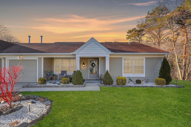 ranch-style home with a garage and a lawn