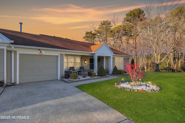 ranch-style house featuring a garage and a yard