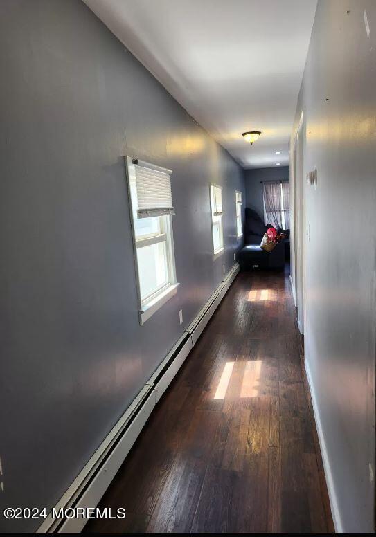 hall featuring dark hardwood / wood-style floors and a baseboard radiator